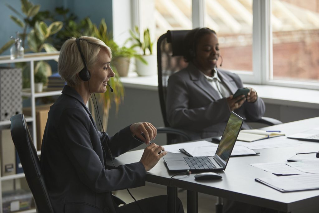 caucasian middle aged woman black young adult woman working office